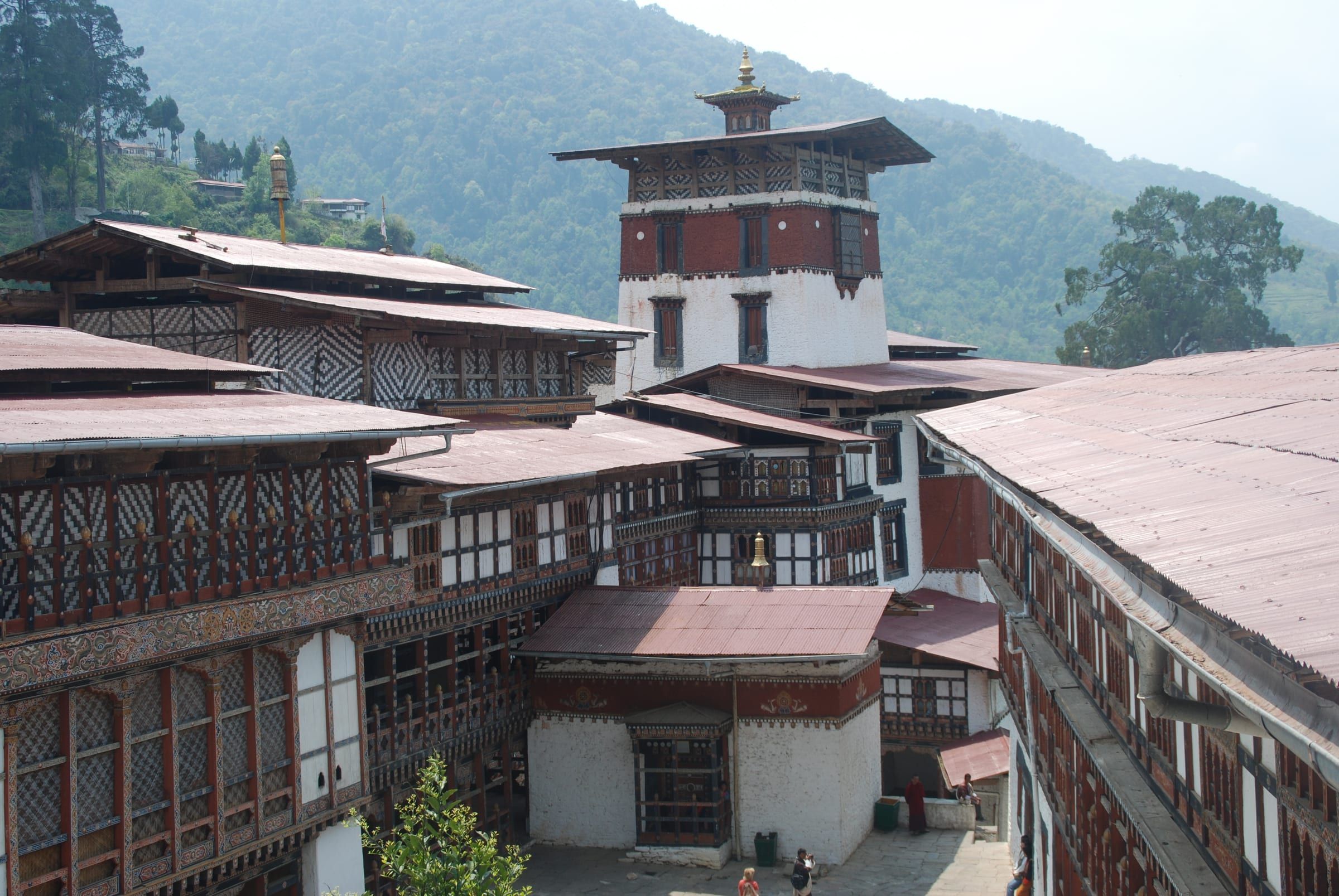 The courtyards, roofs and central tower of Trongsa Dzong seen from above.