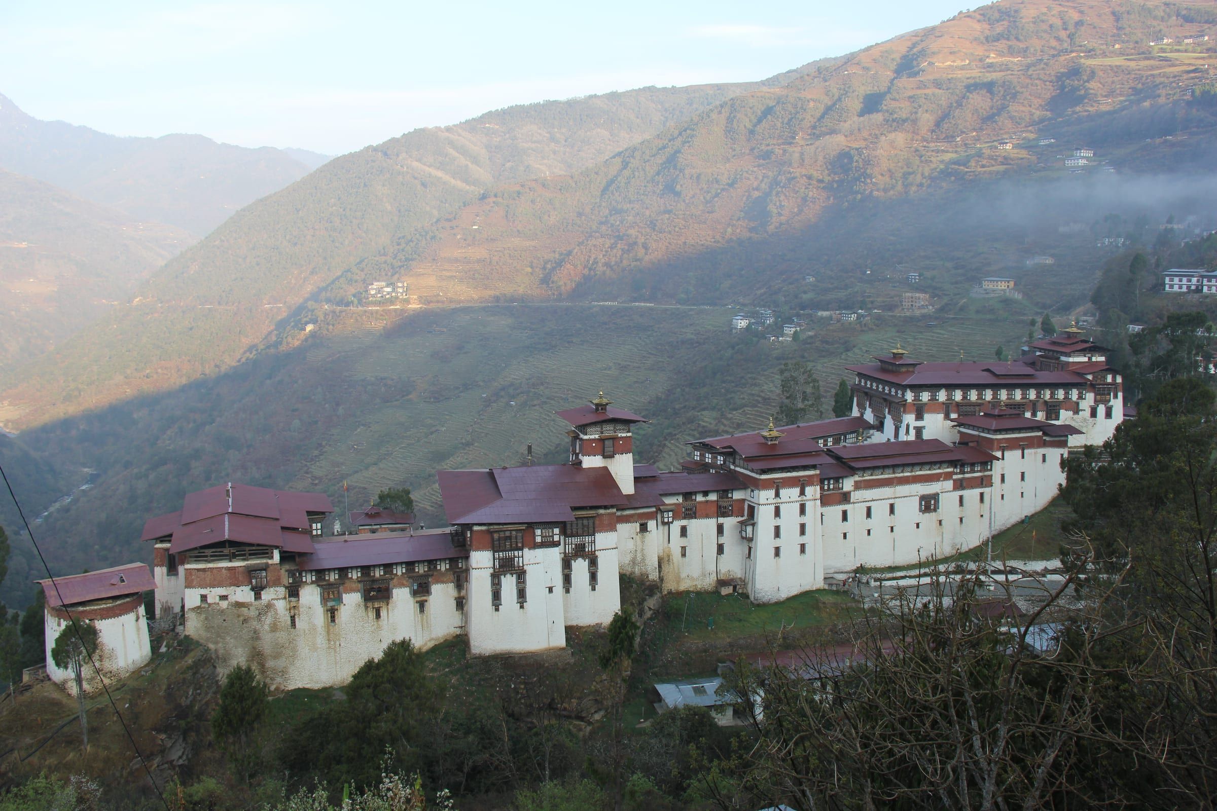 Trongsa Dzong stretched along a ridge above a deep valley.